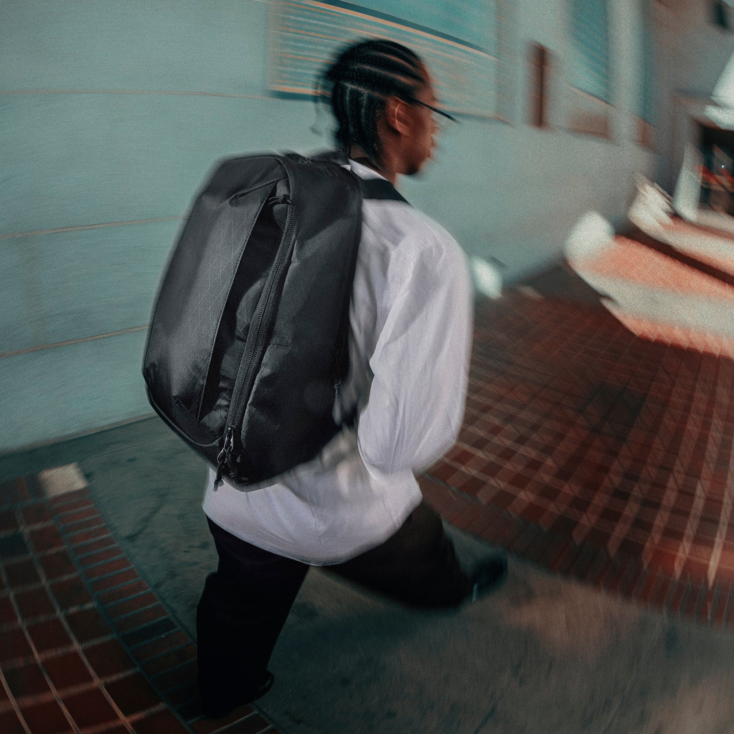 Person with a black backpack walking in an indoor setting
